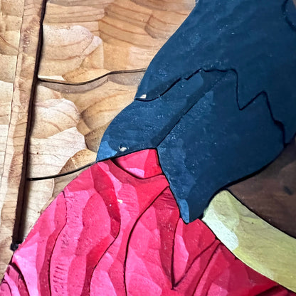 Close-up of a pink wood with a blue and yellow pattern on a wooden surface showing 3 areas where paint is chipped