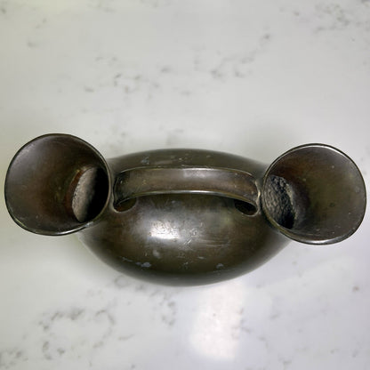 Vintage metal double spout vase  on a marble surface