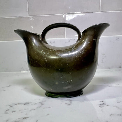 modern-double-spout-metal-vase on a marble countertop with a tiled wall background