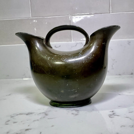modern-double-spout-metal-vase on a marble countertop with a tiled wall background