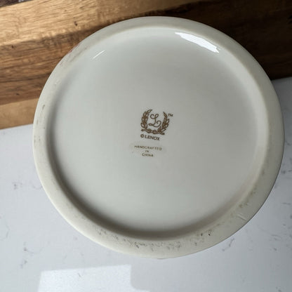 White vase with Lenox logo on a wooden surface