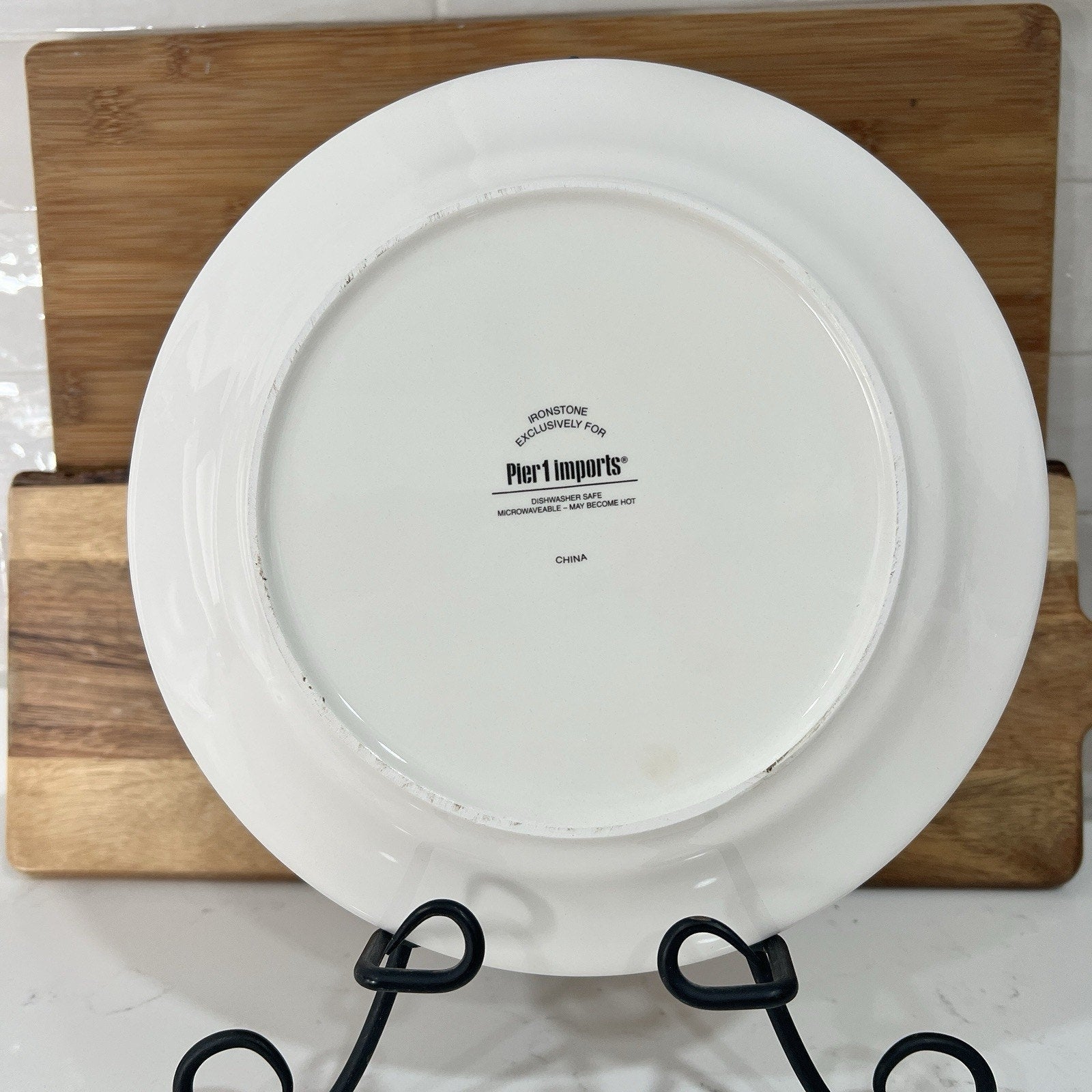 Back of plate white with 'Pier 1 Imports' branding on a wooden cutting board.