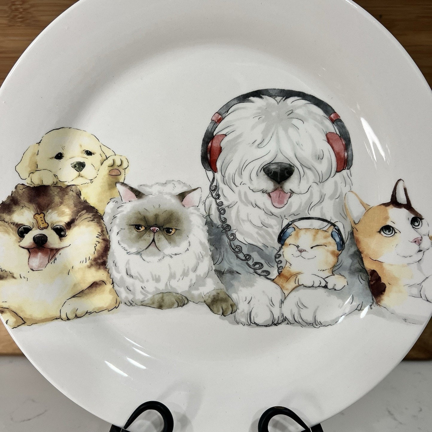 Decorative plate with illustrations of dogs and cats wearing headphones on a white background.