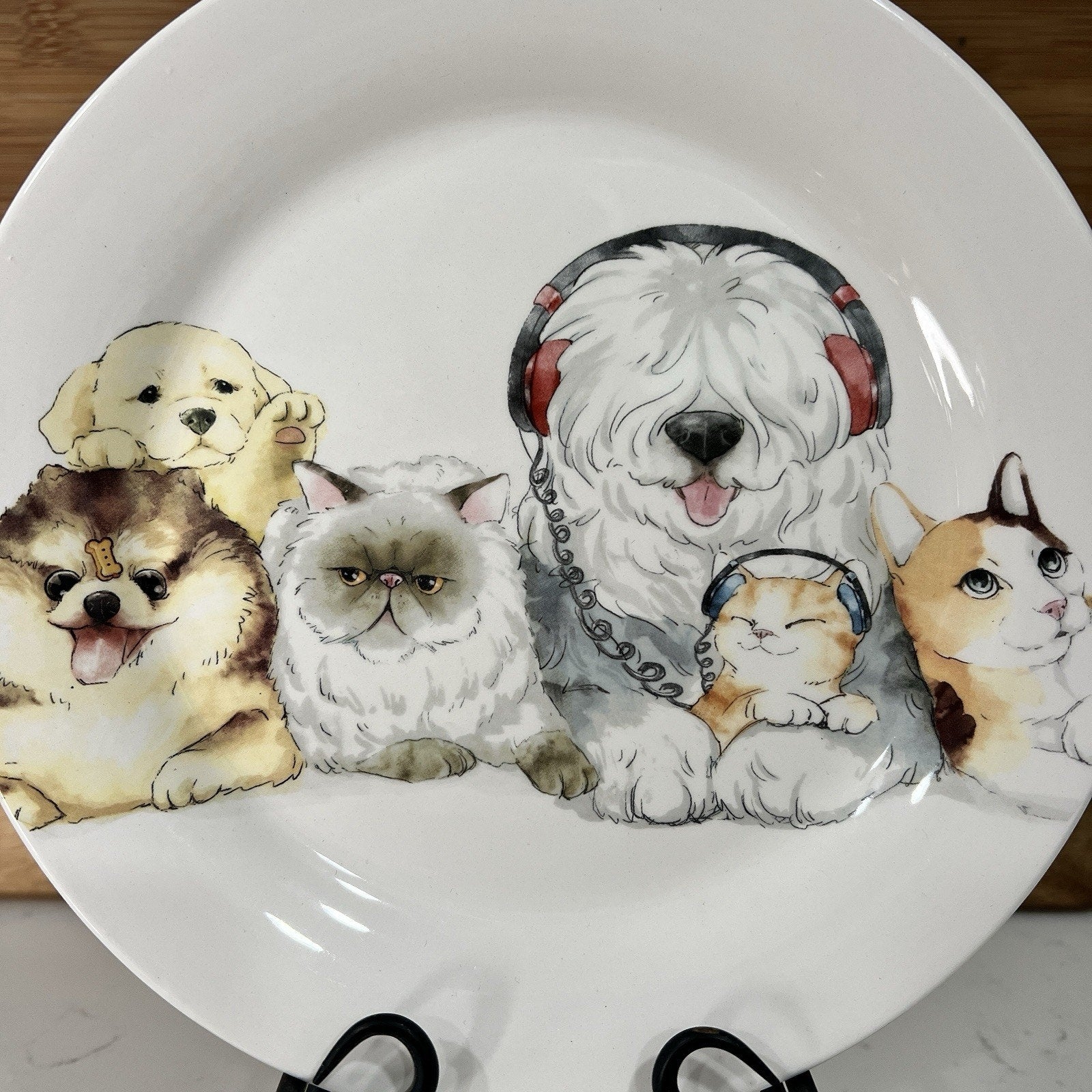 Decorative plate with illustrations of dogs and cats wearing headphones on a white background.