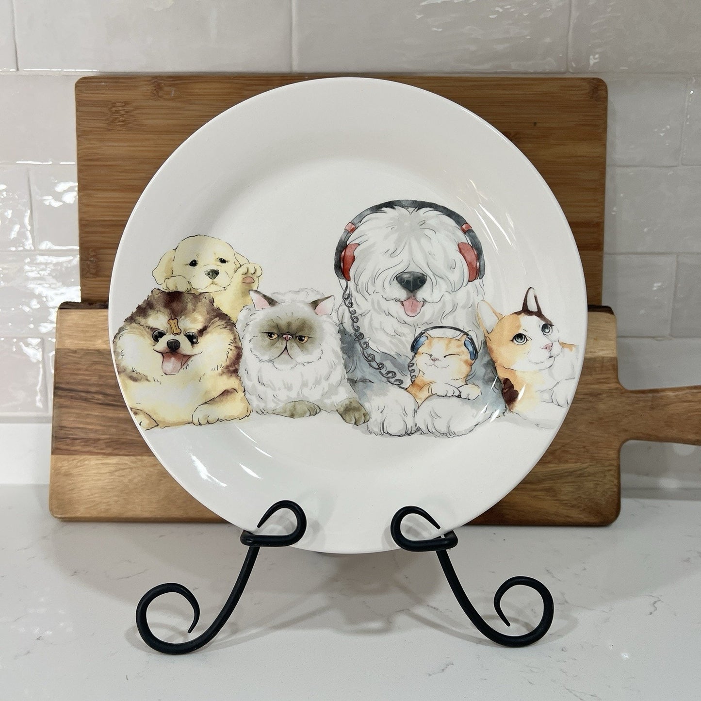 Decorative plate with animal illustrations on a stand against a tiled wall.