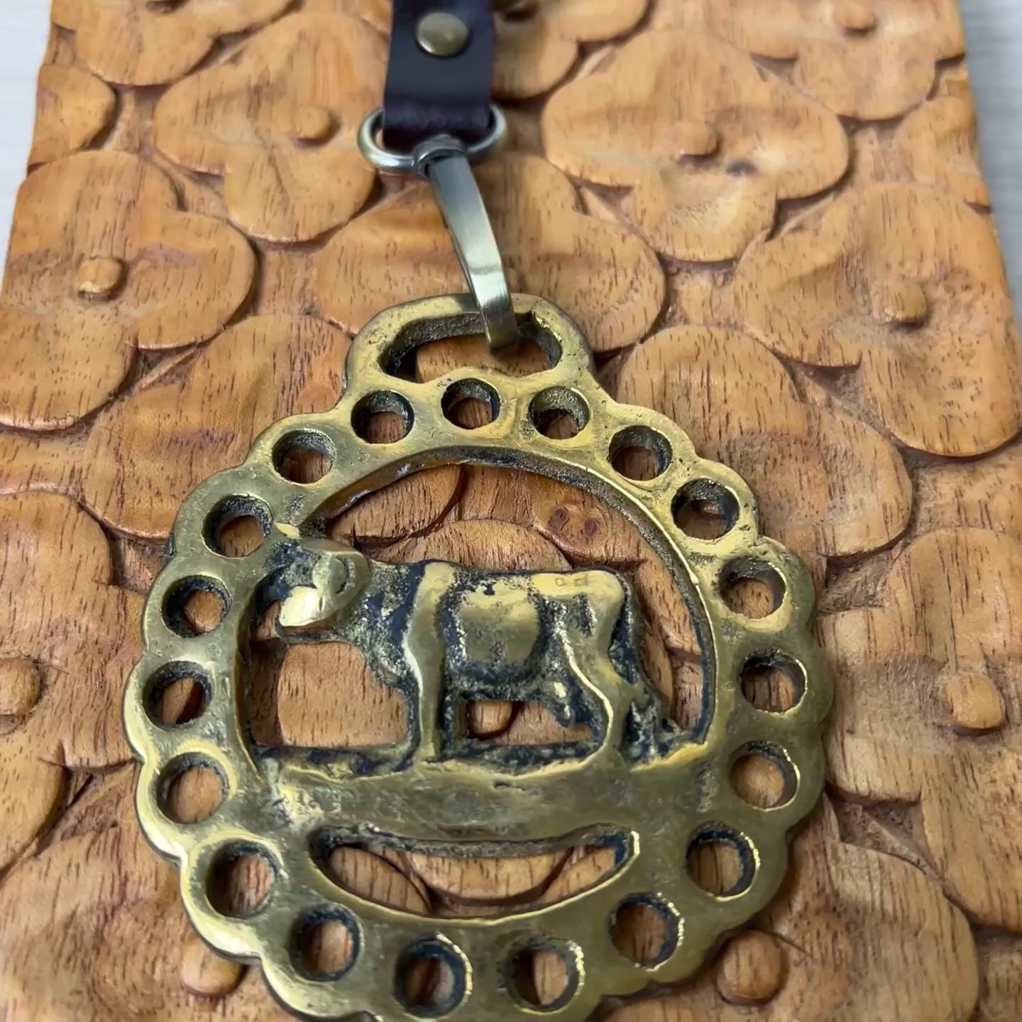 video of Brass Cow Medallion Keychain on woodk surface