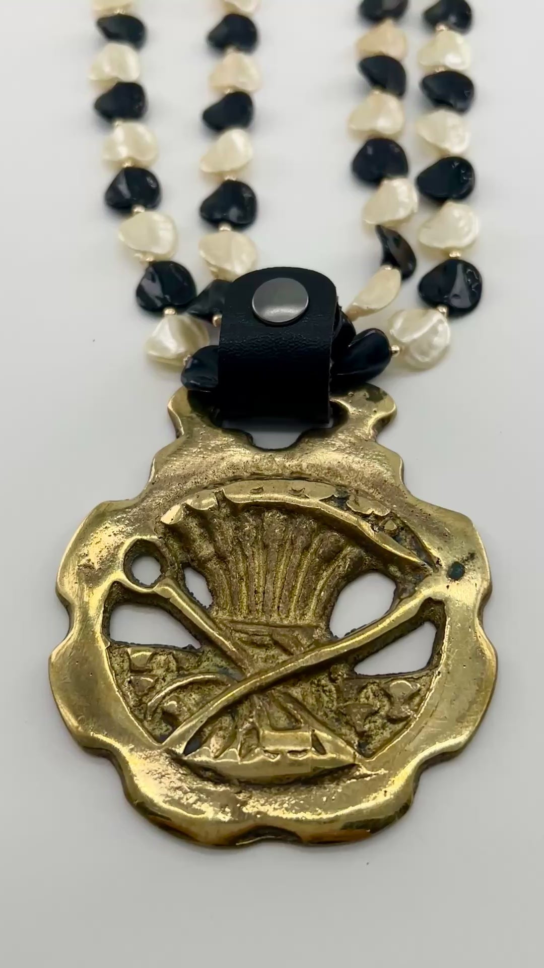 Video of Brass Scythe & Wheat Horse Medallion Necklace on white background
