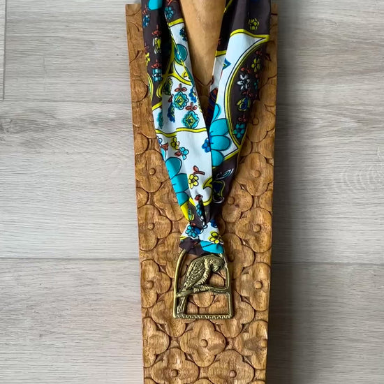 Video of Parrot brass Medallion Necklace on wooden surface