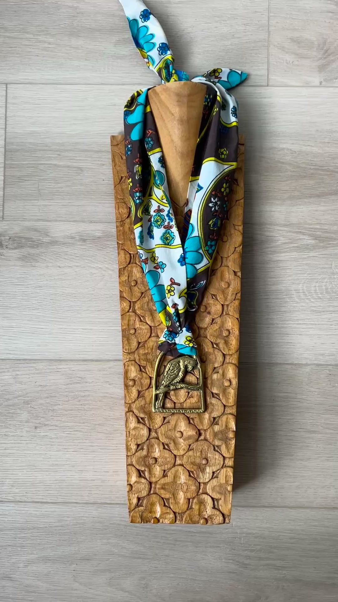 Video of Parrot brass Medallion Necklace on wooden surface