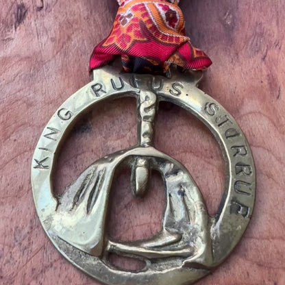 Video Vintage King Rufus Stirrup brass medallion necklace with red paisley scarf, equestrian jewelry on wooden surface