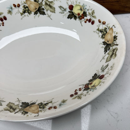 Decorative ceramic plate with fruit and floral pattern on a marble surface