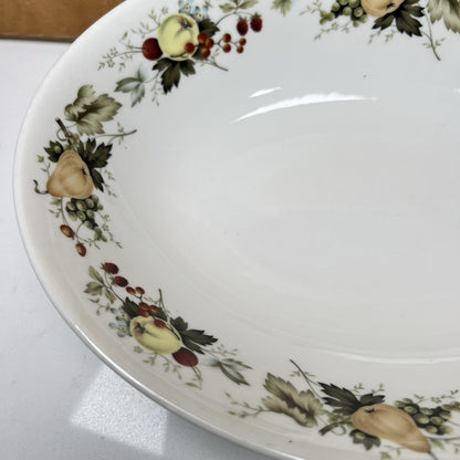 Decorative ceramic plate with fruit and leaf pattern on a white surface