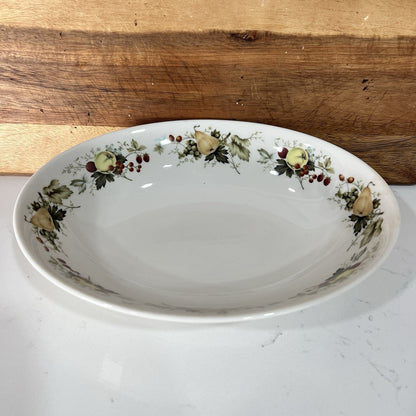 Decorative oval plate with floral patterns on a wooden surface