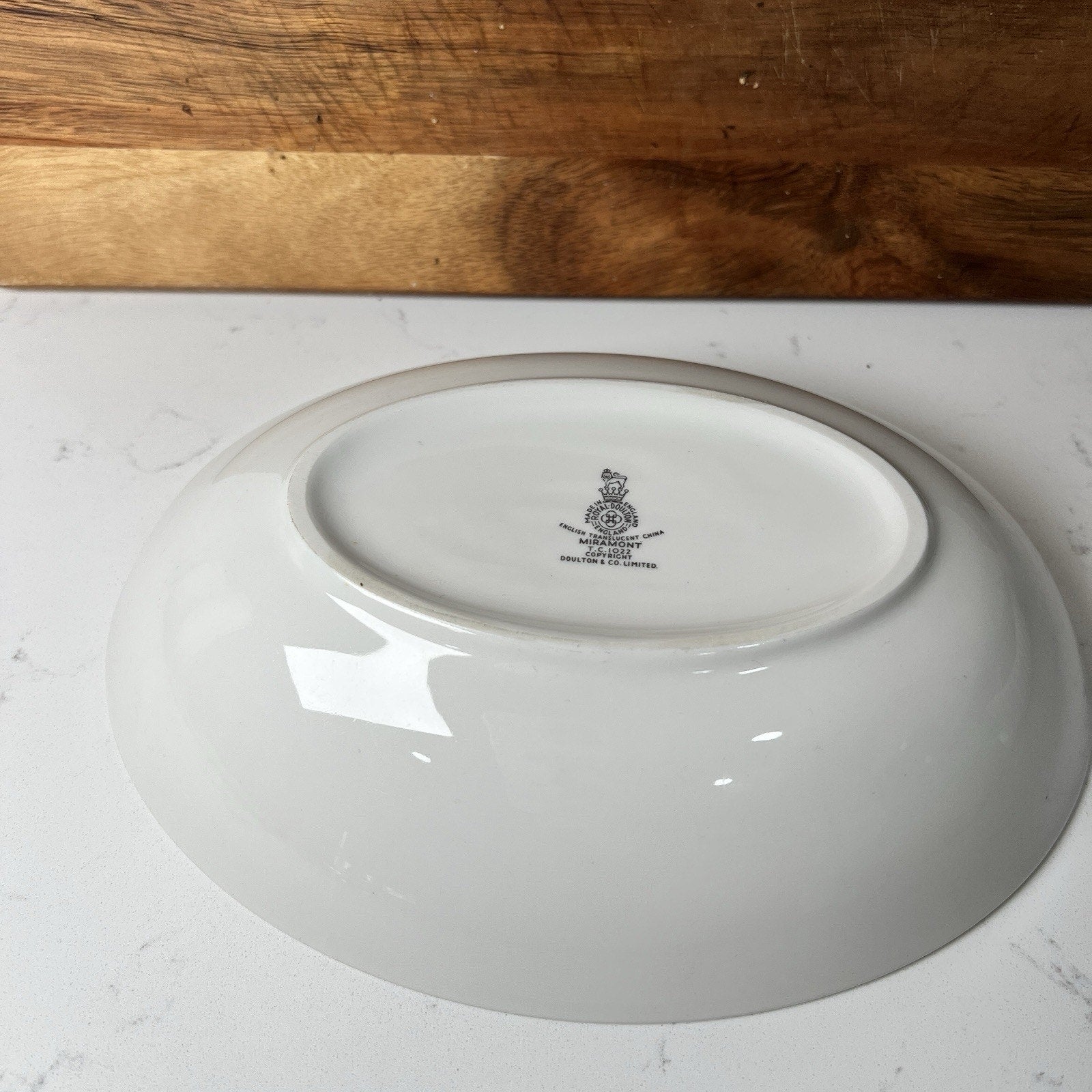White ceramic plate with a logo on a white surface