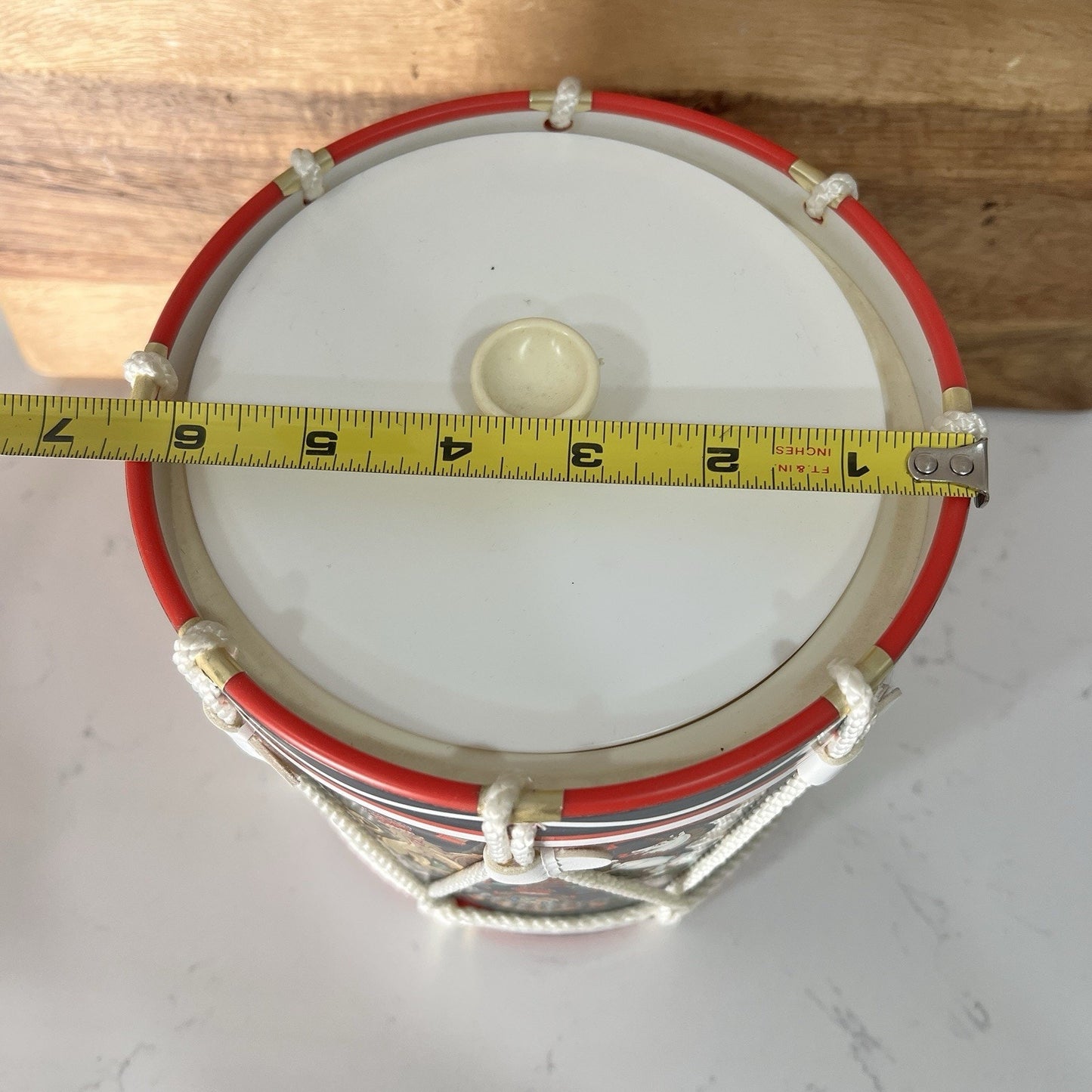 Drum ice bucket with a measuring tape around it on a wooden surface