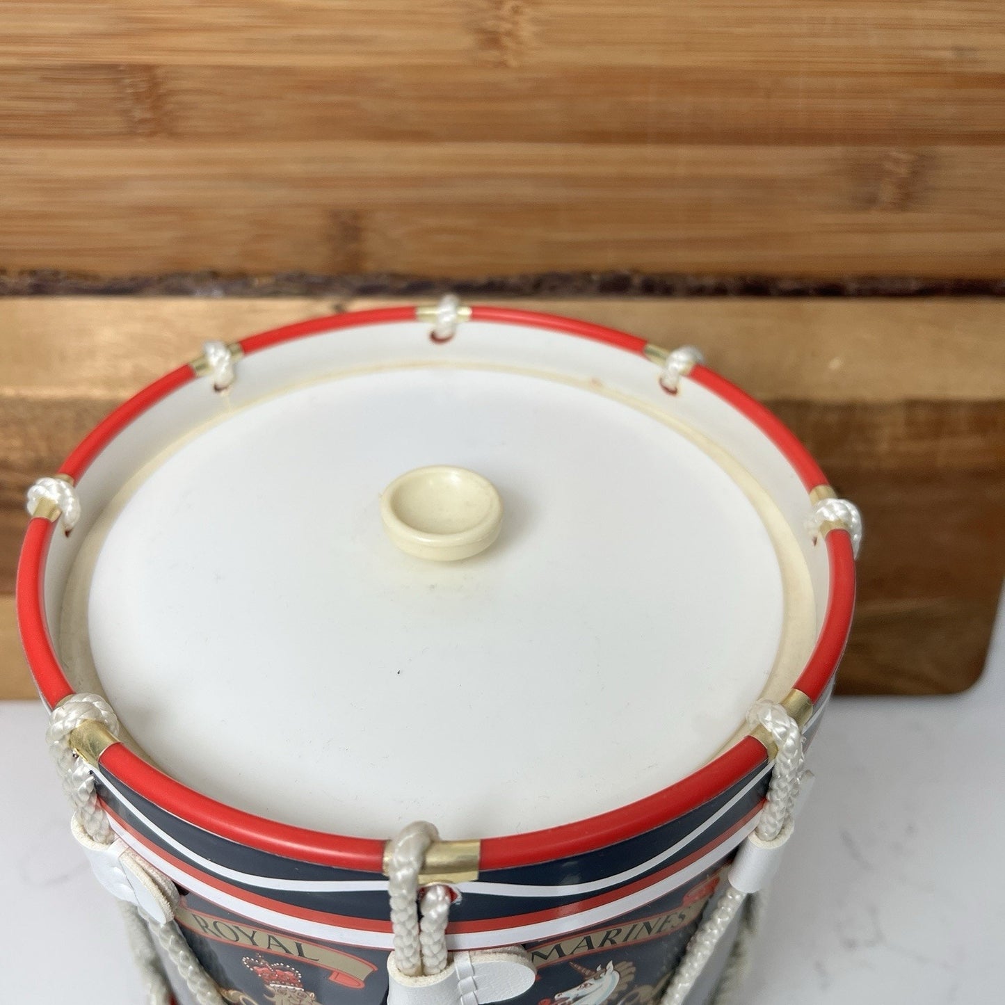 Decorative drum with red, white, and blue stripes on a wooden surface