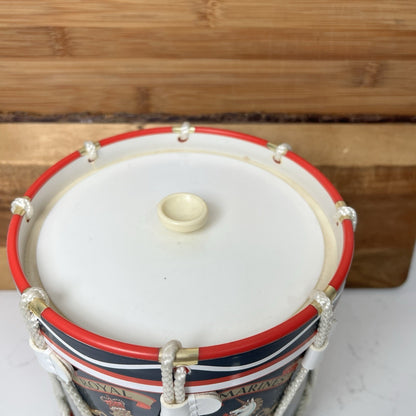 Decorative drum with red, white, and blue stripes on a wooden surface