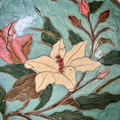 Decorative tile with floral design on a green background