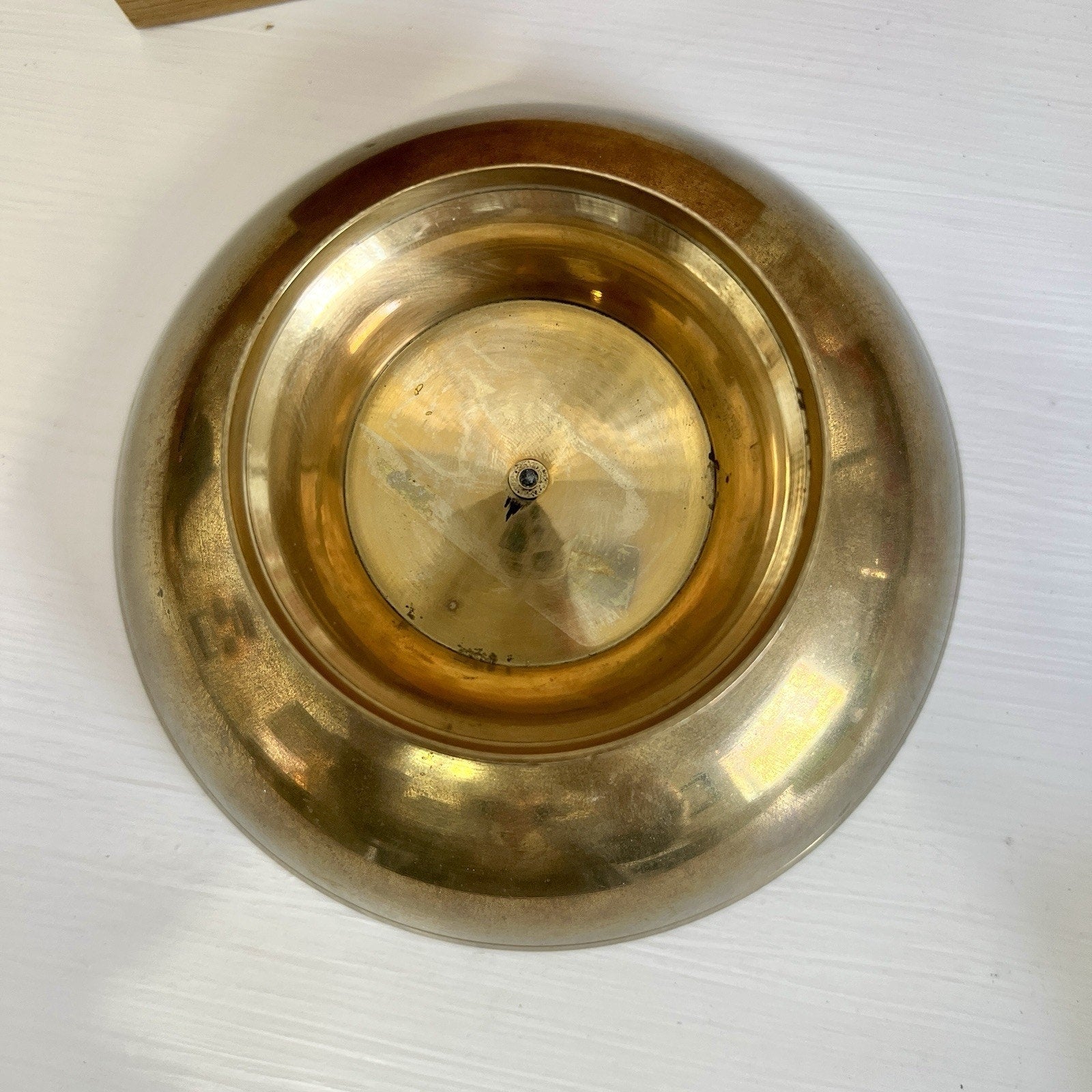 bottom of Brass dish on a white surface