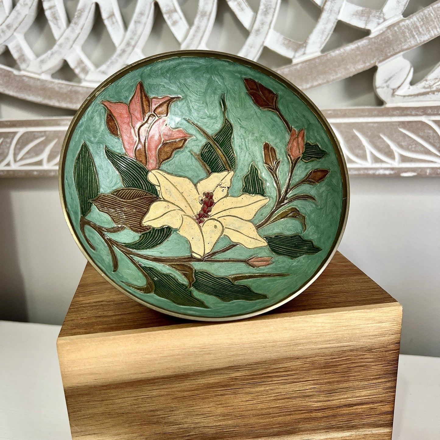 Decorative bowl with floral design on a wooden stand