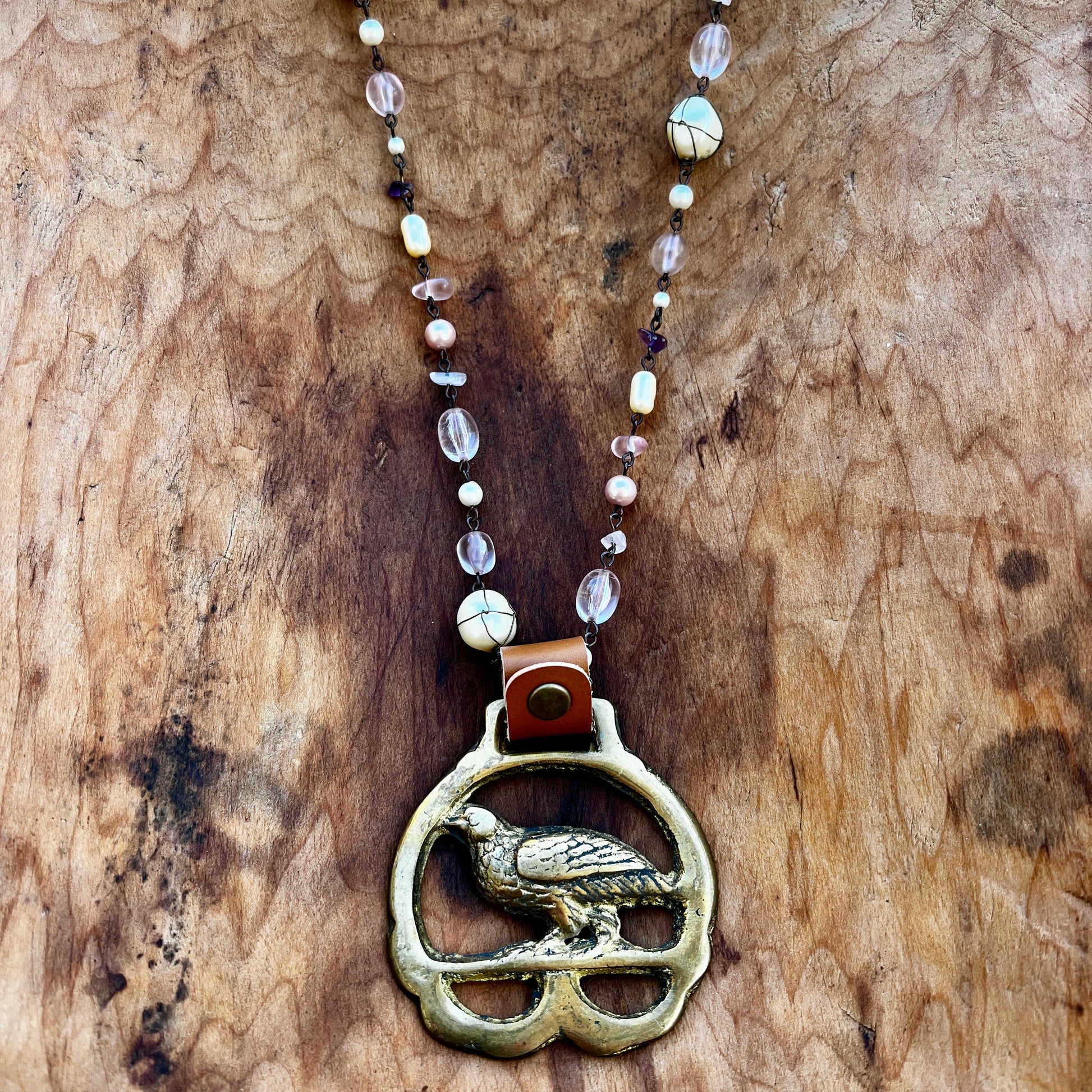 Necklace with a bird pendant on a wooden surface