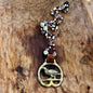 Necklace with a bird pendant and beaded chain on a wooden surface